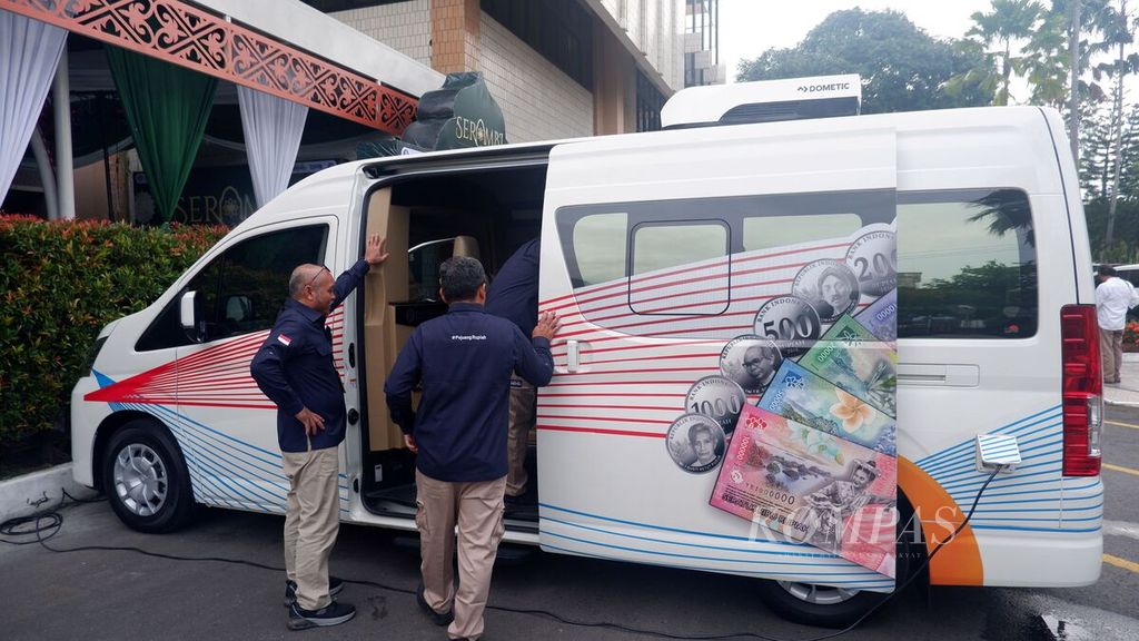 Petugas naik ke mobil kas keliling yang melayani penukaran uang di halaman Kantor Perwakilan Bank Indonesia Provinsi Kalimantan Selatan di Banjarmasin, Jumat (15/3/2024).