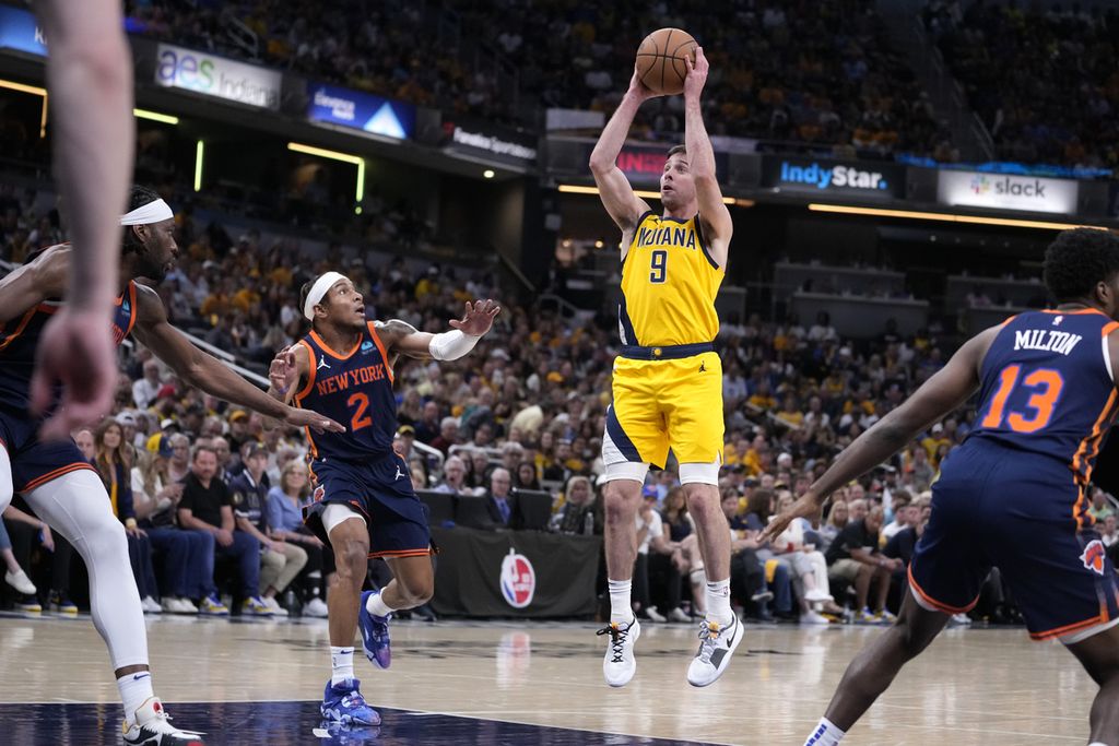 Pemain Indiana Pacers, TJ McConnell (tengah/9), melempar bola dan melewati pemain New York Knicks, Miles McBride (kedua dari kiri/2), pada laga keempat semifinal Wilayah Timur NBA, Minggu (12/5/2024), di Stadion Gainbridge Fieldhouse, Indiana, Amerika Serikat. Pacers menang dengan skor 121-89.