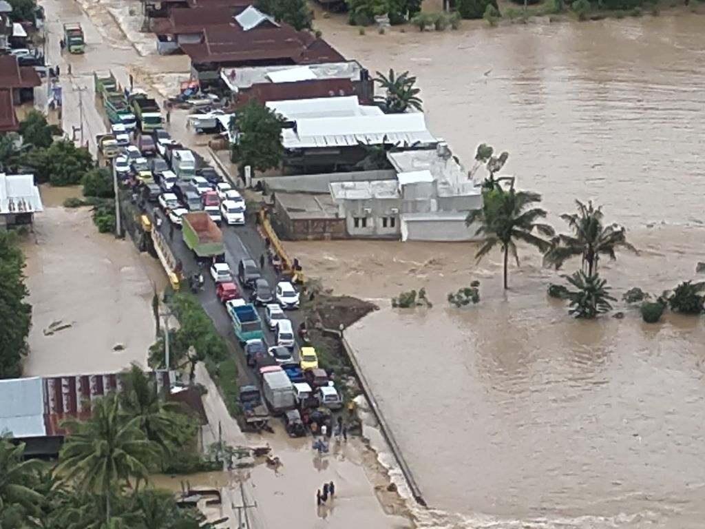 Kendaraan terjebak banjir di Jalan Trans-Sulawesi di Kabupaten Sidrap, Sulawesi Selatan, Jumat (3/5/2024). Sebanyak enam kabupaten diterjang banjir dan longsor.