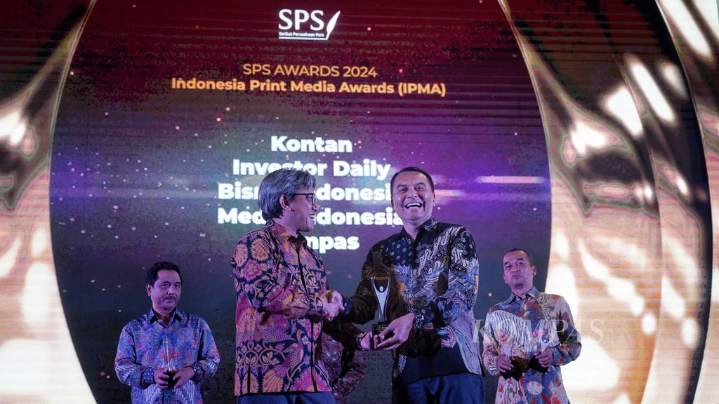 Deputy Chief Editor of the Daily <i>Kompas</i> Adi Prinantyo (right) receives the gold medal trophy for the best national newspaper category of the Press Company Union (SPS) which was handed over by SPS Secretary General Asmono Wikan at the 2024 SPS Awards at the Ciputra Hotel, Jakarta , Wednesday (30/4/2024). The daily <i>Kompas</i> won 4 gold medals and 4 silver medals in several award categories at the 2024 SPS Awards.