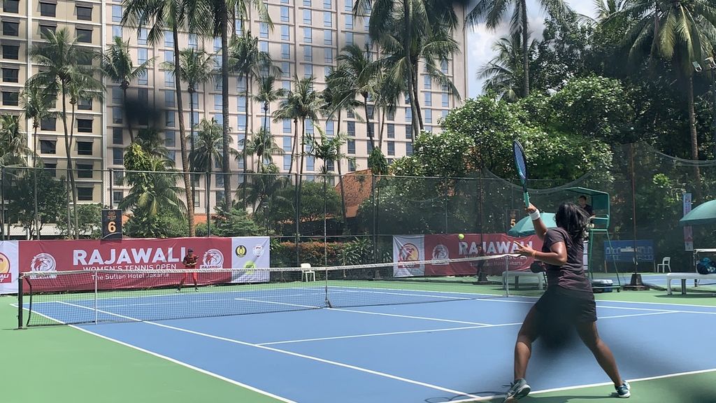 Suasana pertandingan petenis DKI Jakarta, Fitriana Sabrina (hitam), melawan petenis Jawa Tengah, Monica Putri Kusuma (merah), pada turnamen Rajawali Open 2022 di lapangan tenis Hotel Sultan, Jakarta, Kamis (1/12/2022). Fitriana, yang merupakan unggulan pertama, menang dua set langsung, 6-0, 6-0, atas Monica.