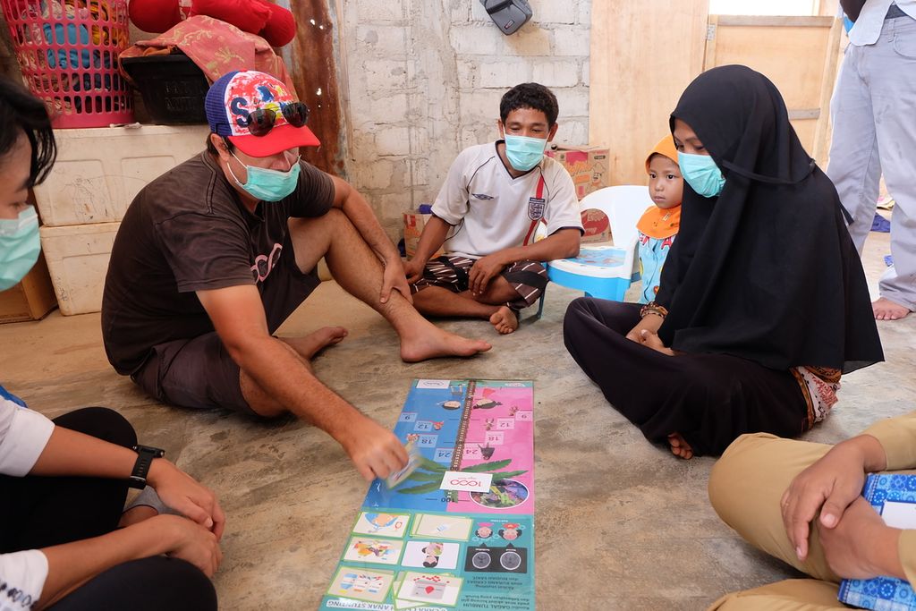 Lead Strategist 1000 Days Fund, Zack Petersen, memberi edukasi pencegahan tengkes berbekal poster pintar kepada seorang ibu hamil di Pulau Papagarang, Manggarai Barat, Nusa Tenggara Timur, Senin (23/11/2020).