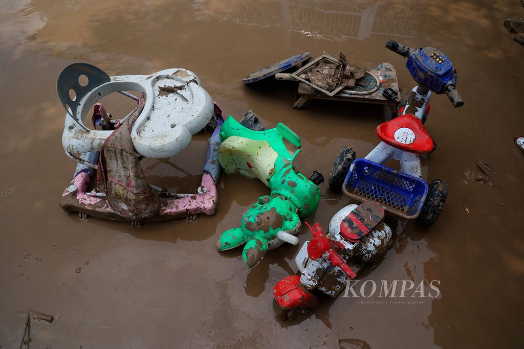 Mainan anak-anak di tengah lumpur sisa dari banjir bandang yang melanda Rowosari, Kecamatan Tembalang, Kota Semarang, Jawa Tengah, Sabtu (7/1/2022). 