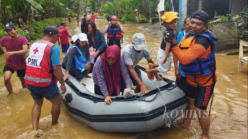 Petugas dan sukarelawan mengevakuasi warga Desa Sitiarjo, Kecamatan Sumbermanjing Wetan, Kabupaten Malang, Jawa Timur, saat terjadi banjir pada Sabtu (15/10/2022). Pada Senin (17/10/2022), Desa Sitiarjo kembali tergenang lagi oleh banjir serupa bersama sejumlah desa lain di Malang dan Blitar.