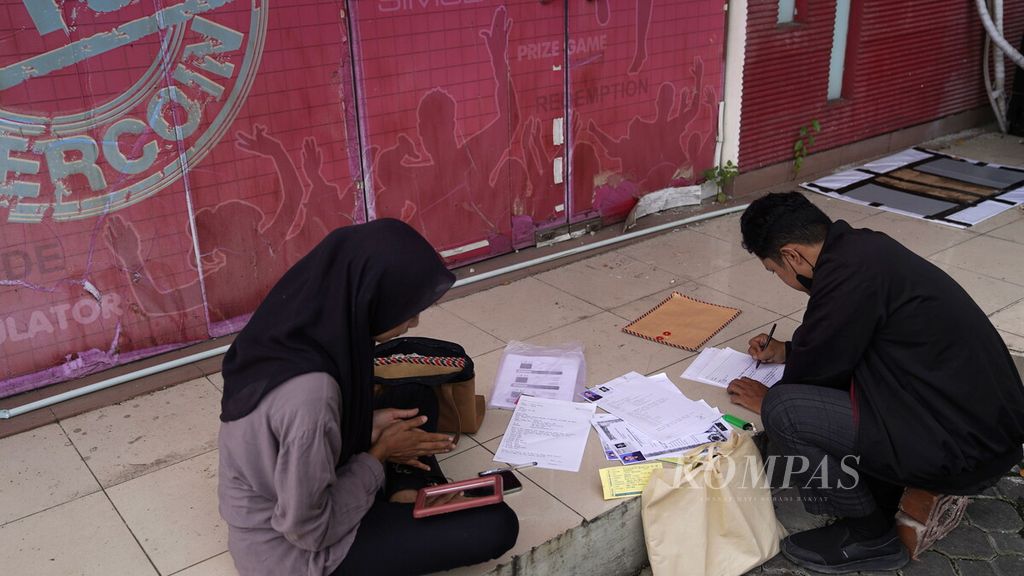 Job seekers fill out documents at a job fair in a shopping center in Bekasi, West Java, on Wednesday (26/7/2023). The Central Statistics Agency recorded an unemployment rate of 5.45 percent and a half-unemployment rate of 9.59 percent, resulting in a total of 15.04 percent.