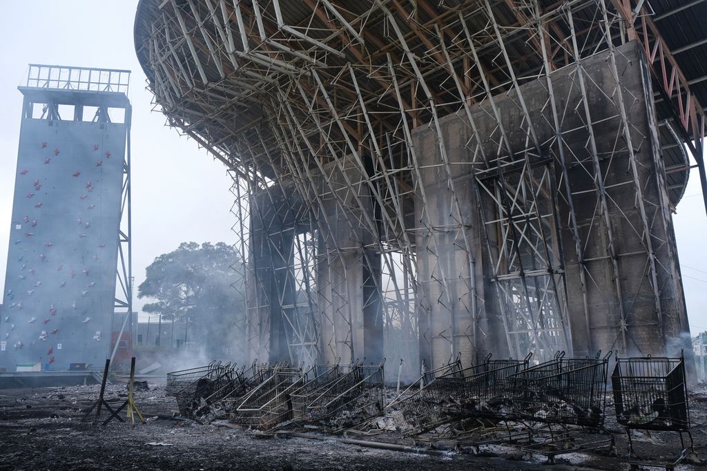 Dinding yang terbakar di Distrik Magenta, Noumea, Kaledonia Baru, 15 Mei 2024, di tengah protes tentang debat rancangan undang-undang terkait pemilu. Lebih dari 130 orang ditahan dalam kerusuhan. 