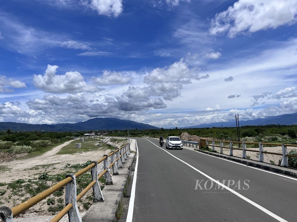 Kendaraan melintas di jalan raya yang membelah Desa Jono Oge di Kecamatan Sigi Biromaru, Sulteng, Senin (27/3/2023).