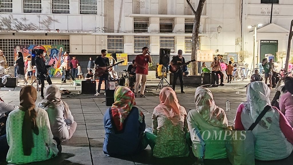 Para pengunjung menikmati sajian musik yang menghibur dari Komunitas Musik KotaTua Bersatu di Kota Tua Jakarta, Kamis (21/12/2023).
