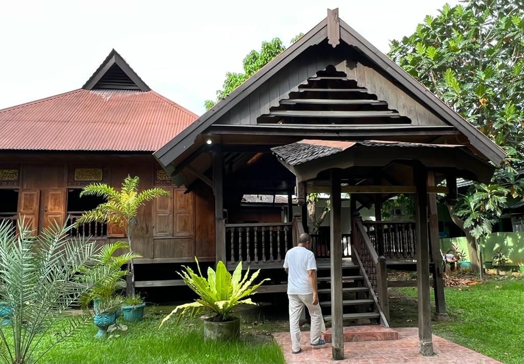 A Patahuddin Mallombassang  enters his stilt house on Jalan Sultan Alauddin, Makassar. This house has been inhabited by three generations. One of the roofs resembles the shape of a traditional house in Central Java.