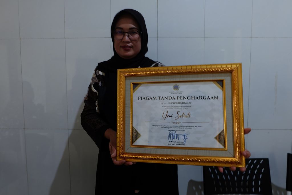 Yeni Setiati, Kuwu atau Kepala Desa Babakangebang di Kecamatan Babakan, Kabupaten Cirebon, Jawa Barat, pada Jumat (21/7/2023) menunjukkan piagam Hassan Wirajuda Pelindungan WNI Award tahun 2021. 
