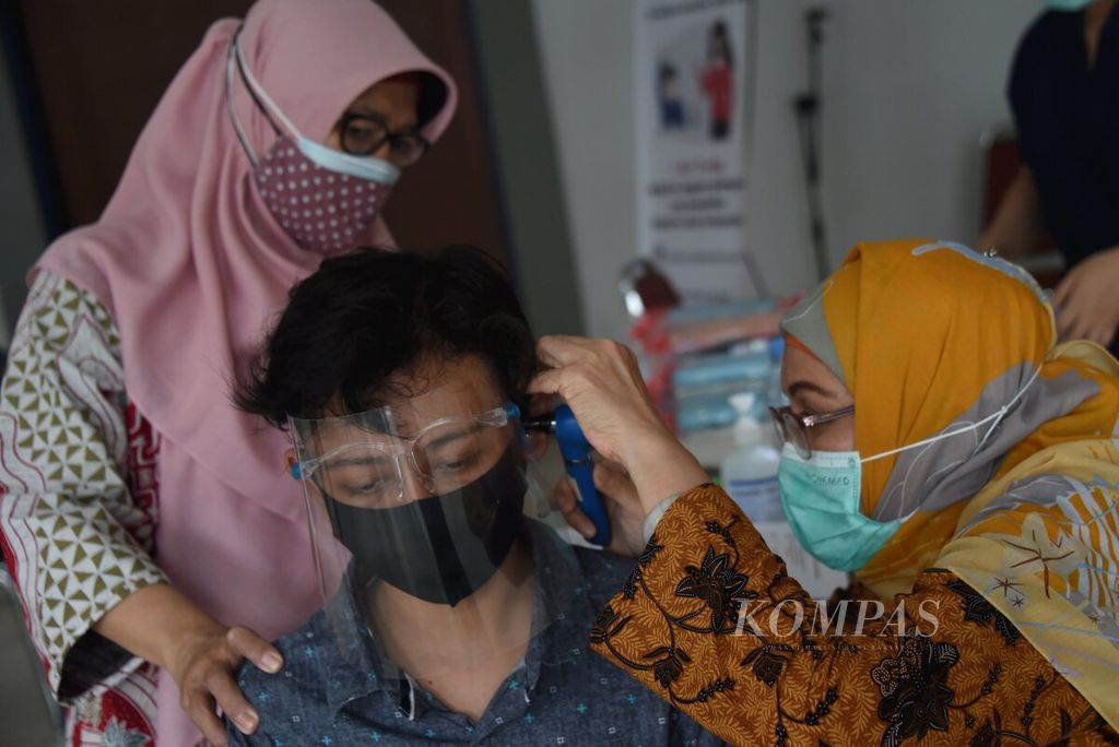 Petugas medis memeriksa kondisi telinga Siswa SLB B Karya Mulia saat acara "Peduli Pendengaran Untuk Semua" , Surabaya, Jawa Timur, Rabu (24/2/2021). 