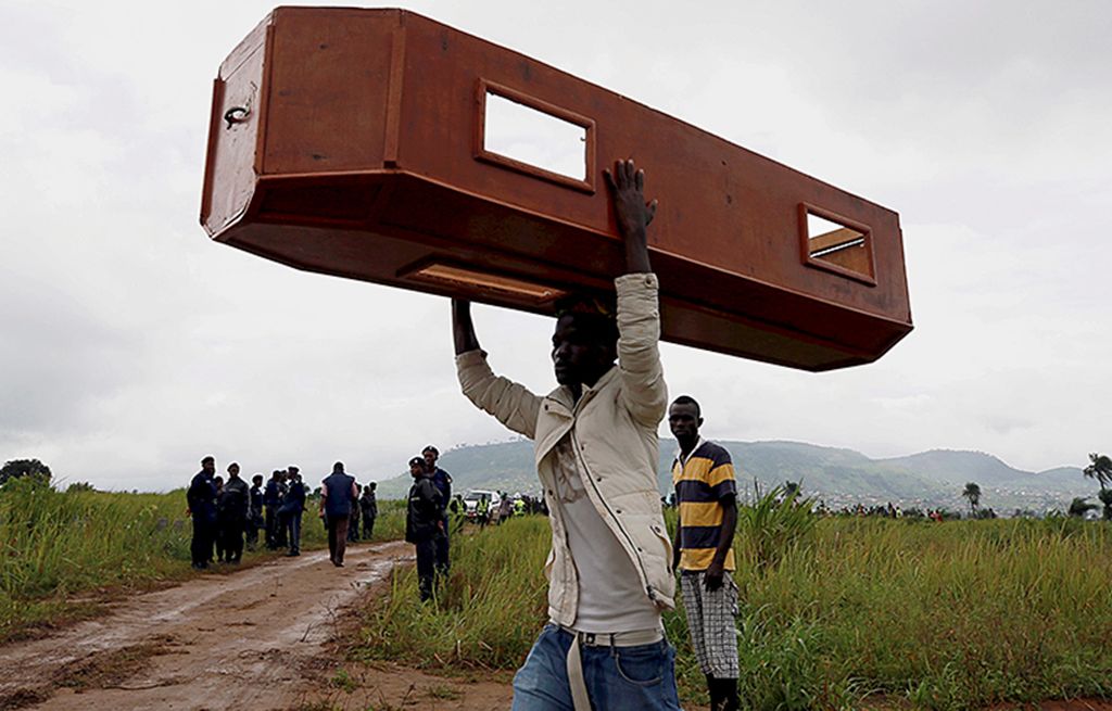 Seorang pria membawa peti mati kosong di pemakaman Paloko, di Waterloo, Sierra Leone, Kamis (17/8).  Ratusan korban meninggal akibat banjir di Sierra Leone dimakamkan di Waterloo.   
