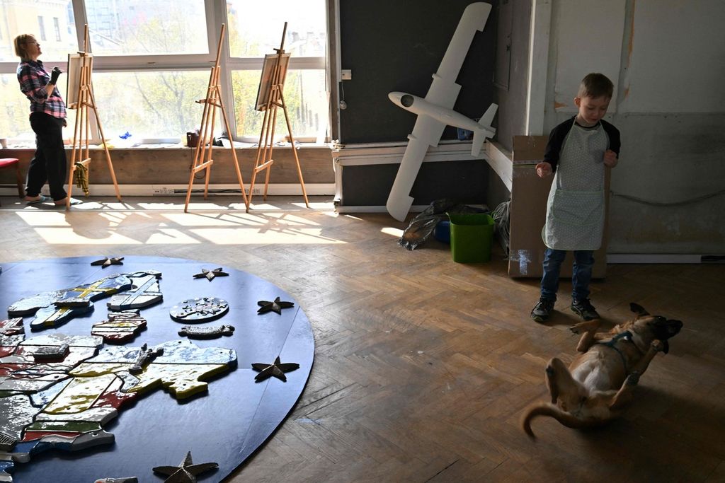 Seorang anak laki-laki bermain-main dengan seekor anjing dalam acara bengkel terapi seni berjudul ”Live” yang digelar yayasan Modern Ukraina bagi para perempuan yang kehilangan suami dan anak-anak selama perang Rusia-Ukraina, Sabtu (6/4/2024) di Kyiv. 