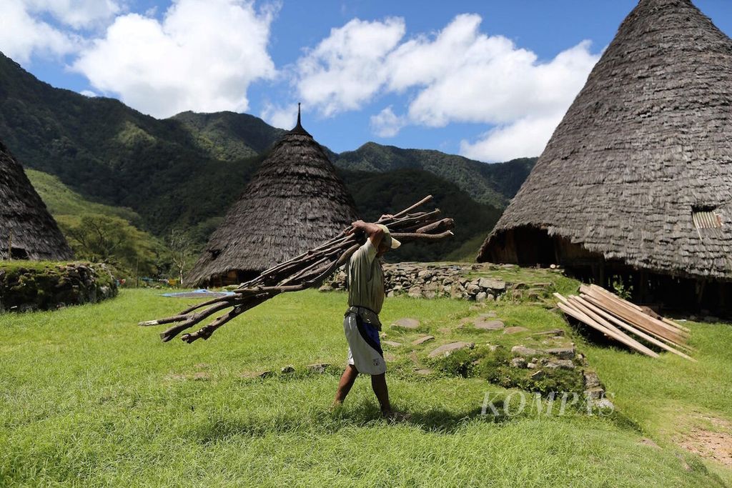 Warga Kampung Adat Waerebo, yang berada di lembah yang dikelilingi pegunungan di kawasan Satar Mese Barat, Manggarai, Nusa Tenggara Timur, membawa kayu bakar sepulang dari merawat kebun, Kamis (8/2/2018).