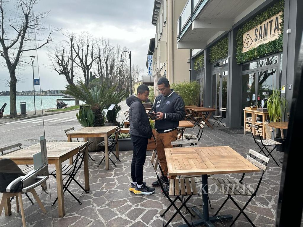 Qarrar (13), pebalap Gokar 3 dunia asal Indonesia, bersama ayahnya, Firhand Ali, untuk santap siang di Restoran Santa La Pizza Buona E Giusta di Desenzano del Garda, Italia, Sabtu (2/3/2024).