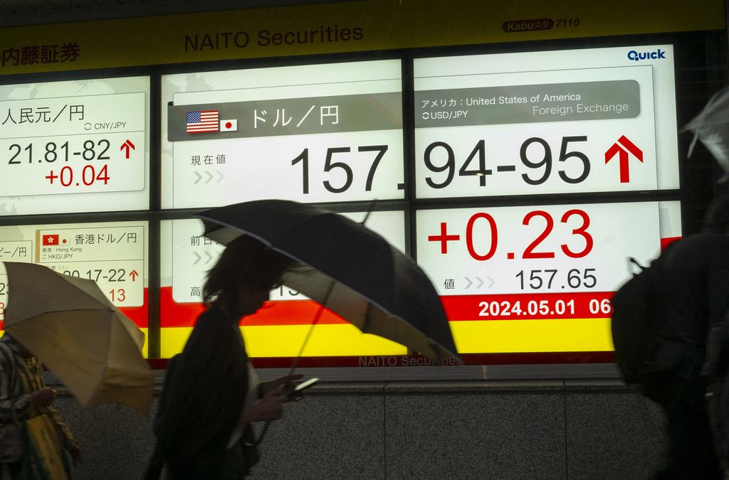 Pejalan kaki melintas di depan papan elektronik yang memajang nilai tukar mata uang yen terhadap dollar AS di Tokyo, Jepang, 1 Mei 2024. 