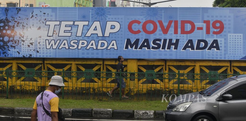 Imbauan untuk tetap mewaspadai Covid-19 terpasang di kawasan Tanah Abang, Jakarta, Kamis (17/2/2022). Di wilayah DKI Jakarta terjadi tren penurunan kasus dalam empat hari terakhir, tetapi lonjakan kasus diperkirakan akan terjadi di luar wilayah Jawa-Bali dalam beberapa pekan ke depan.
