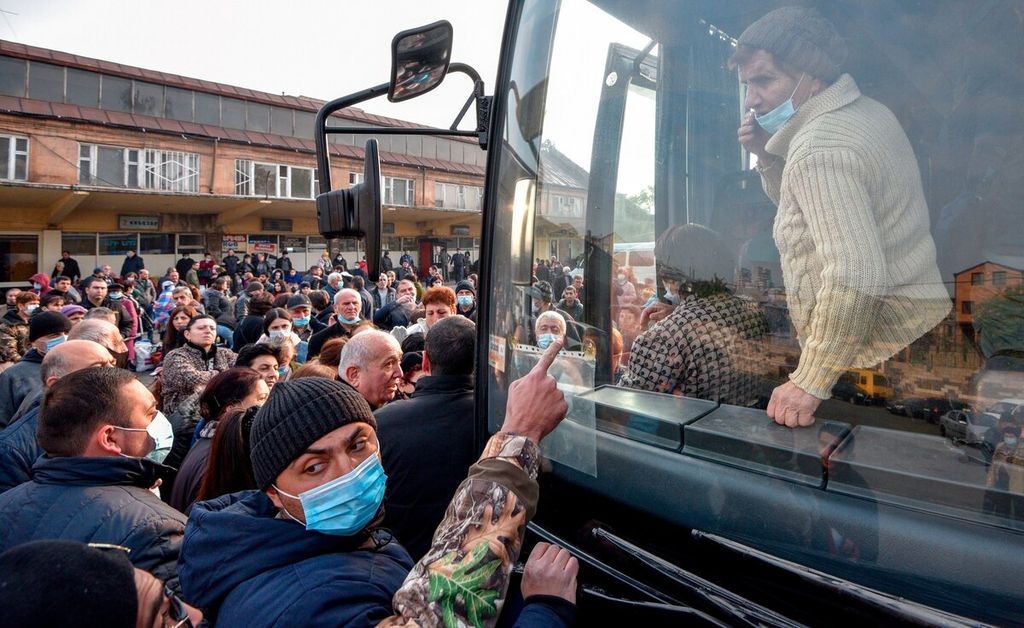Pengungsi dari wilayah Nagorno-Karabakh menaiki bus yang akan membawa mereka kembali ke Stepanakert, dari lokasi pengungsian di Yerevan, Selasa (17/11/2020). Warga Armenia mulai kembali ke Nagorno-Karabakah sepekan setelah gencatan senjata Armenia-Azerbaijan yang ditengahi oleh Rusia.