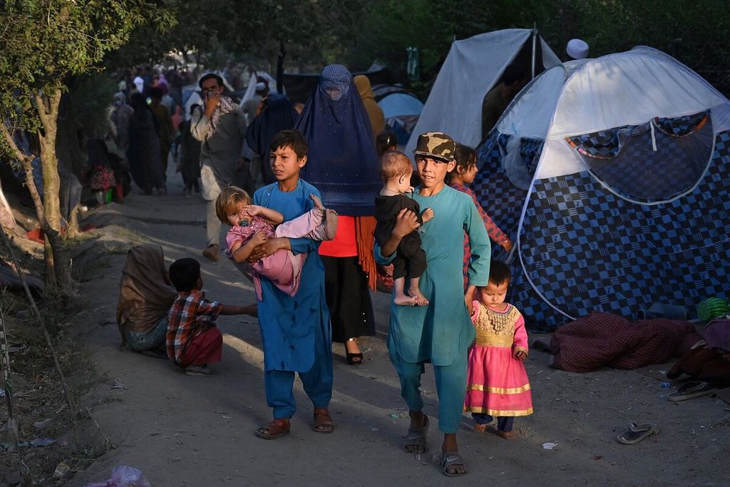 Warga termasuk anak-anak yang melarikan diri dari provinsi Kunduz, Takhar dan Baghlan karena pertempuran antara Taliban dan pasukan keamanan Afghanistan, mengungsi sementara di Sara-e-Shamali di Kabul, Afghanistan, Rabu (11/8/2021). (Photo by Wakil KOHSAR / AFP)