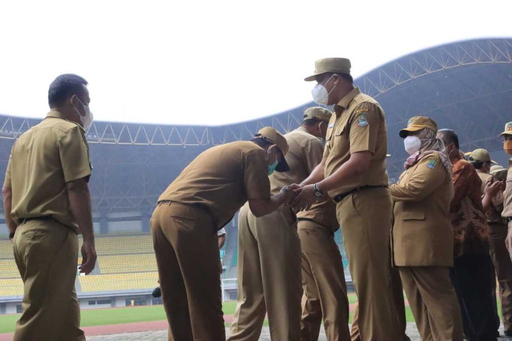 Pelaksana Tugas Wali Kota Bekasi Tri Adhianto bersalaman dengan ASN Kota Bekasi seusai apel di Stadion Patriot Candrabhaga, Kota Bekasi, Jawa Barat, Senin (9/5/2022) pagi.