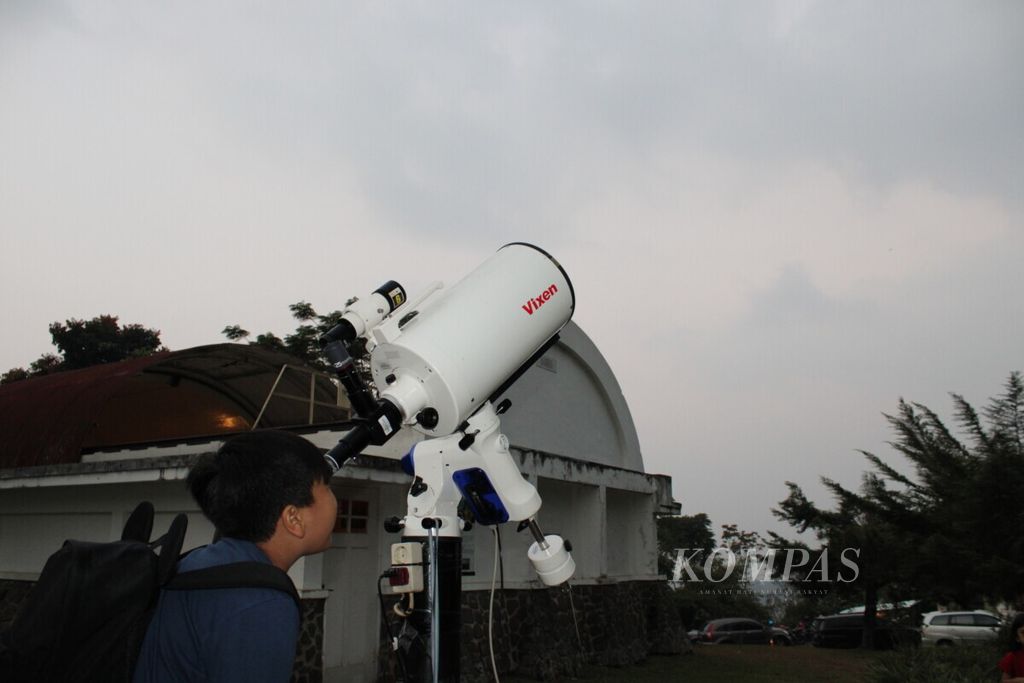 Pengunjung mencoba melihat bulan dengan menggunakan teleskop dalam acara <i>open house </i>peringatan 50 tahun pendaratan pertama manusia di Bulan di Observatorium Bosscha, Kabupaten Bandung Barat, Jawa Barat, Sabtu (13/7/2019).