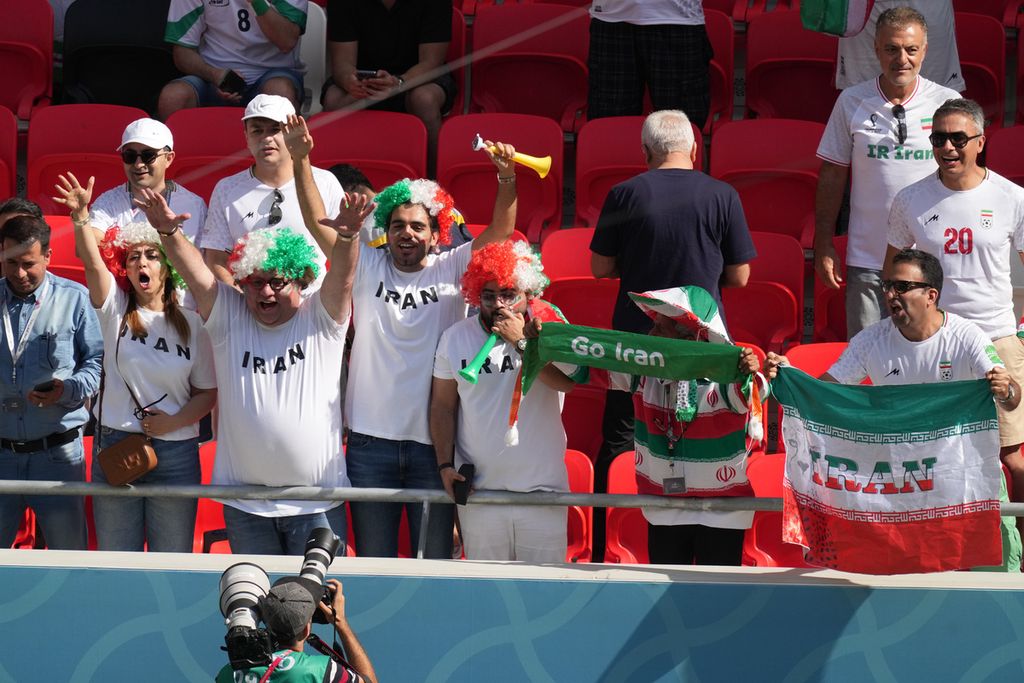 Pendukung tim Iran bersemangat saat menonton pertandingan Wales melawan Iran di babak fase Grup B Piala Dunia 2022 di Stadion Ahmad Bin Ali, Qatar, Jumat (25/11/2022). Iran menang, 2-0. 