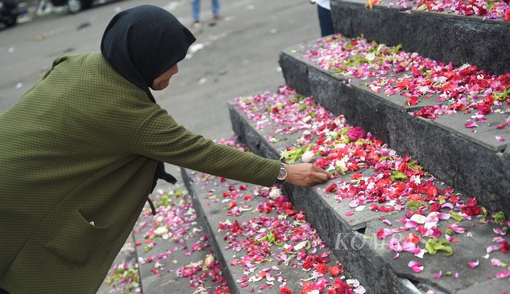 Warga meletakkan bunga bagi korban meninggal akibat kerusuhan di Patung Singo Tegar yang berada di kompleks Stadion Kanjuruhan, Kabupaten Malang, Jawa Timur, Minggu (2/10/2022). 