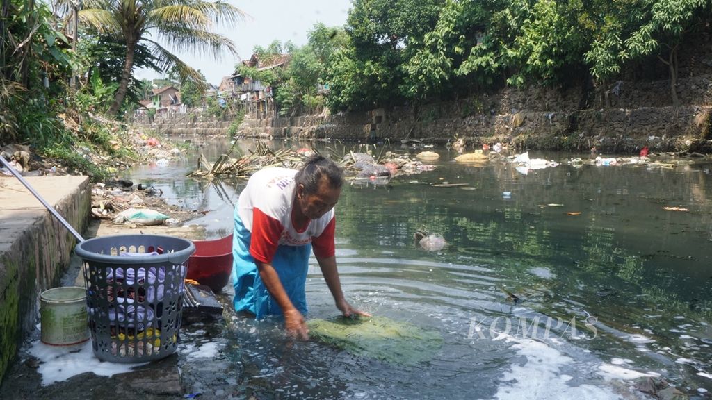 Warga Kelurahan Gedung Pakuan, Kecamatan Teluk Betung Selatan, Kota Bandar Lampung, memanfaatkan sungai yang kotor dan penuh sampah untuk mencuci, Jumat (23/8/2019).