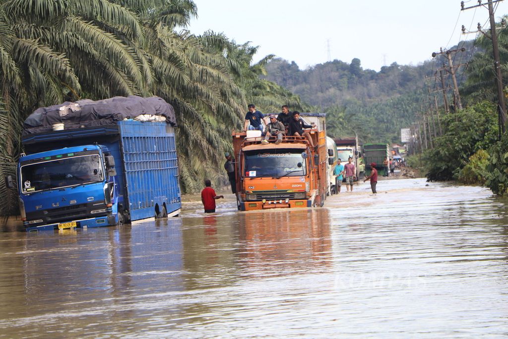 Sebuah truk mencoba melewati genangan banjir di Jalan Medan-Banda Aceh di Kecamatan Kejuruan Muda, Kabupaten Aceh Tamiang, Aceh, Minggu (6/11/2022). Sudah enam hari lalu lintas lumpuh akibat banjir. Sayur-mayur dari Medan membusuk dan ayam banyak yang mati, sementara Pupuk dari Aceh tertahan dan sebagian mulai rusak diterjang banjir dan hujan. Penanganan pemerintah sangat minim.