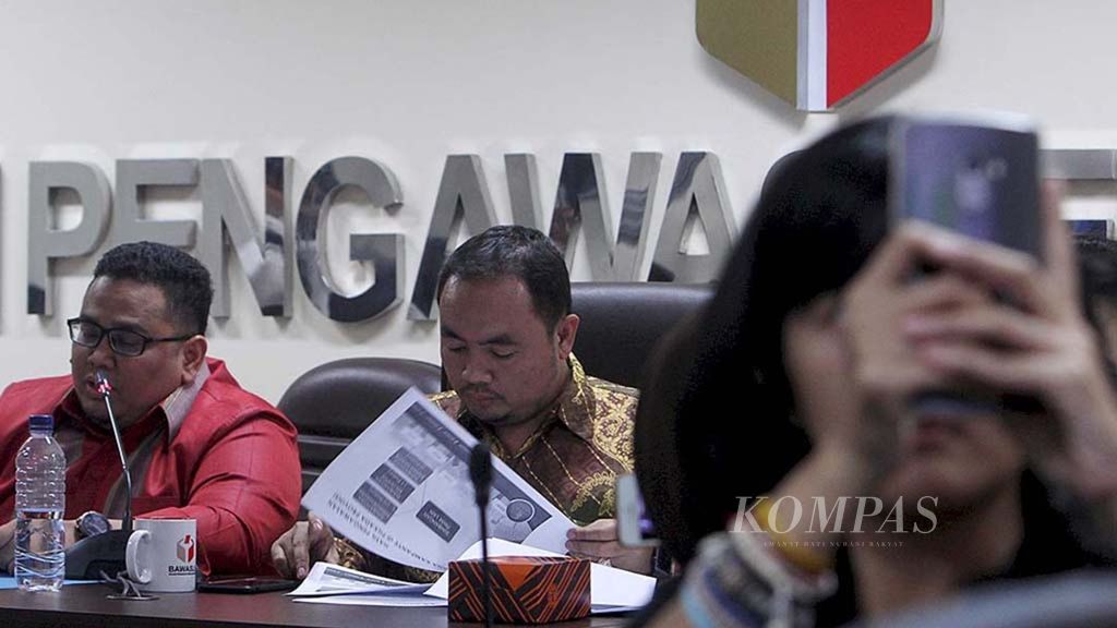 Anggota Bawaslu, Mochammad Afifuddin (tengah) bersama Rahmat Bagja (kiri), mengadakan jumpa pers di kantor Bawaslu, Jakarta, Senin (12/3/2018).
