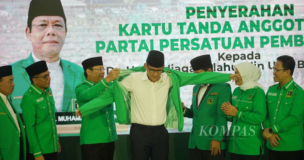 Sandiaga Salahuddin Uno (tengah) mengenakan jaket yang diserahkan Pelaksana Tugas Ketua Umum Partai Persatuan Pembangunan (PPP) Muhammad Mardiono (ketiga dari kiri) pada acara penyerahan kartu tanda anggota partai di Jakarta, Rabu (15/6/2023).