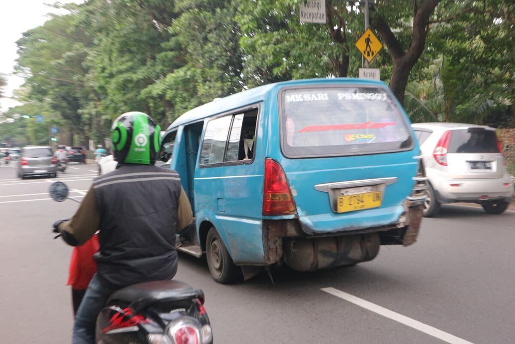 Sebuah angkot dengan trayek Mekarsari-Pasar Minggu yang tidak memiliki bumper belakang sedang melintas di Jalan Lenteng Agung Raya, dari Depok arah Jakarta Selatan, pada Senin (6/2/2023).