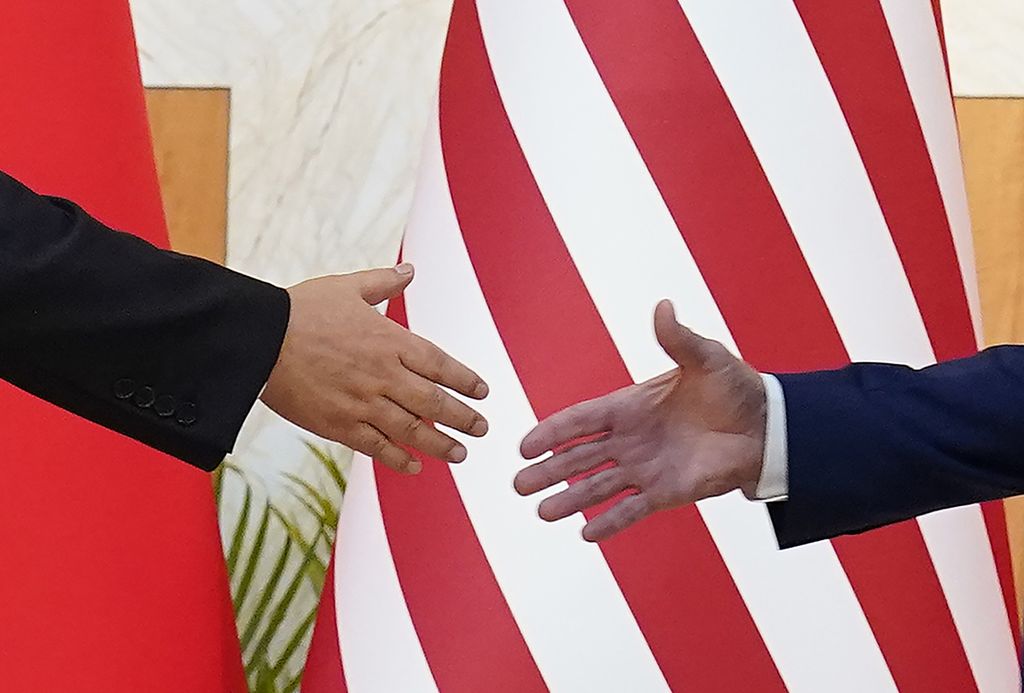 Tangan Presiden AS Joe Biden (kanan) dan tangan Presiden China Xi Jinping saling menggapai untuk berjabat dalam pertemuan mereka di sela KTT G20 di Nusa Dua, Bali, Senin (14/11/2022). 
