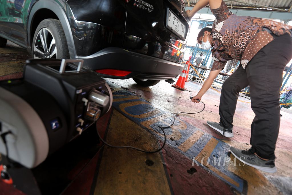 Petugas menguji emisi kendaraan dengan alat penganalisis gas buang di kompleks kantor Dinas Lingkungan Hidup DKI di kawasan Cililitan, Jakarta, Kamis (5/1/2023). Pelayanan uji emisi gratis ini berlangsung setiap Selasa dan Kamis.