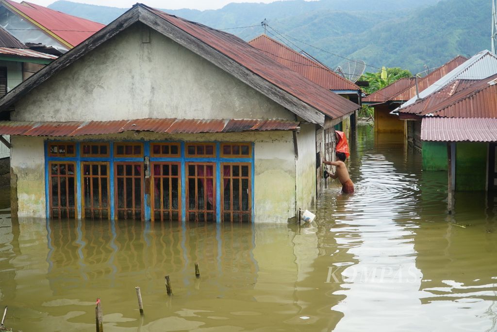 Warga membersihkan dinding rumahnya yang terendam banjir akibat meluapnya Batang Merao di Desa Tanjung, Kecamatan Hamparan Rawang, Kota Sungai Penuh, Jambi, Jumat (19/1/2024). 