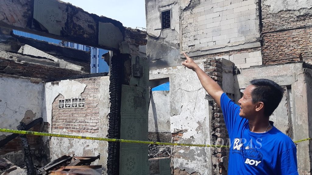 Seorang warga menunjuk titik awal kebakaran yang menghabiskan 38 rumah warga di lingkungan RW 009 Kelurahan Mangga Dua Selatan, Kecamatan Sawah Besar, Jakarta Pusat, Senin (31/1/2022). Kebakaran terjadi pada Kamis (27/1/2022) malam.