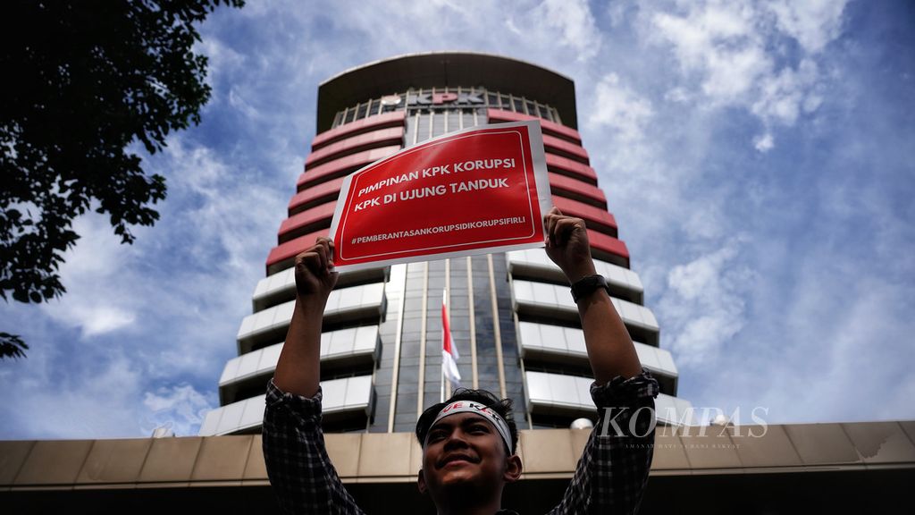 Seorang aktivis antikorupsi yang bergabung dalam Koalisi Masyarakat Sipil Antikorupsi mengangkat poster ketika menggelar aksi Save KPK di depan Gedung KPK, Jakarta, Senin (10/4/2023). 