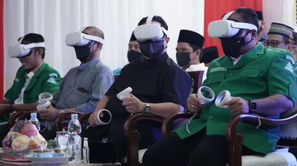 Dua dari kiri Ketua KPU Hasyim Asy'ari, Menteri BUMN Erick Thohir, dan Ketum GP Ansor Yaqut Cholil Qoumas, mengenakan peranti penglihatan virtual <i>reality</i> dalam tasyakuran hari lahir GP Ansor Ke-88, Minggu (24/4/2022) di Jakarta.