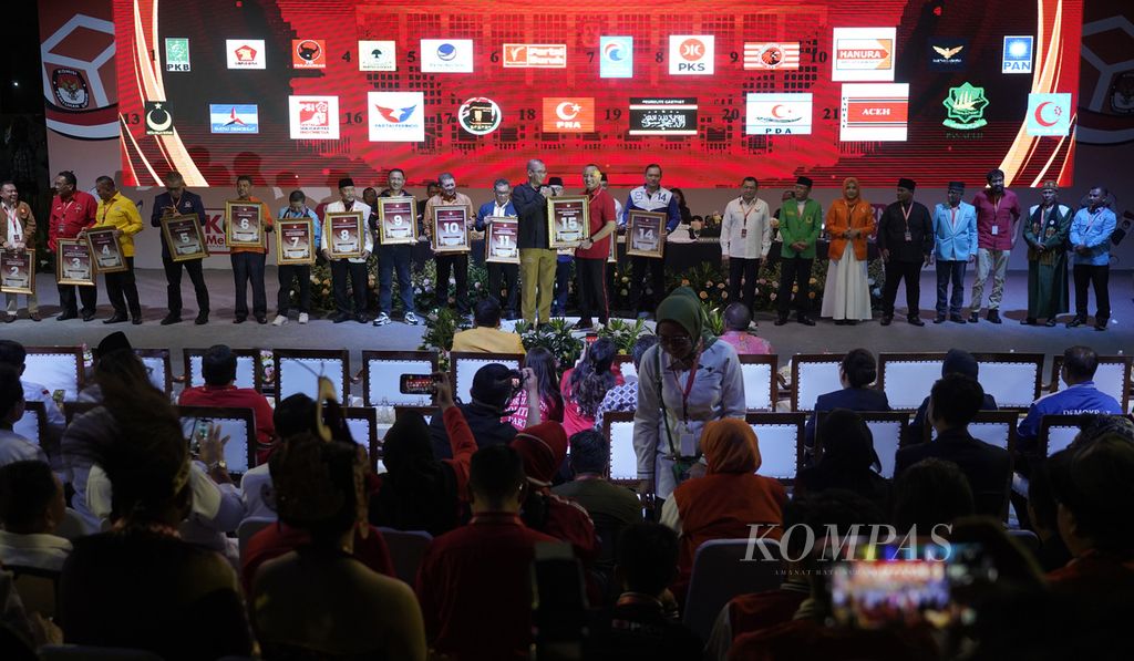 Ketua KPU Hasyim Asyari ketika menyerahkan plakat nomor urut kepada perwakilan pimpinan partai politik peserta Pemilu 2024 dalam acara Pengundian dan Penetapan Nomor Partai Politik Peserta Pemilihan Umum 2024 di halaman Kantor KPU, Jakarta, Rabu (14/12/2022). 