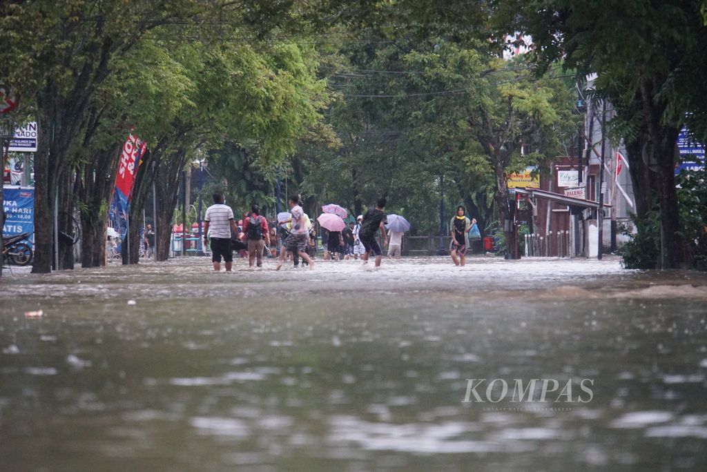 Banjir menggenangi Jalan Lumimuut, Manado, Sulawesi Uatra, setelah hujan deras mengguyur kota, Sabtu (16/1/2021).