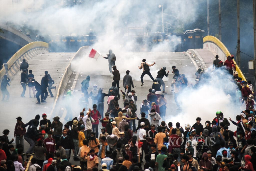 Pelajar menghindari gas air mata saat terlibat bentrok dengan polisi dalam aksi unjuk rasa di kawasan Jalan Layang Slipi, Petamburan, Jakarta, 25 September 2019. 