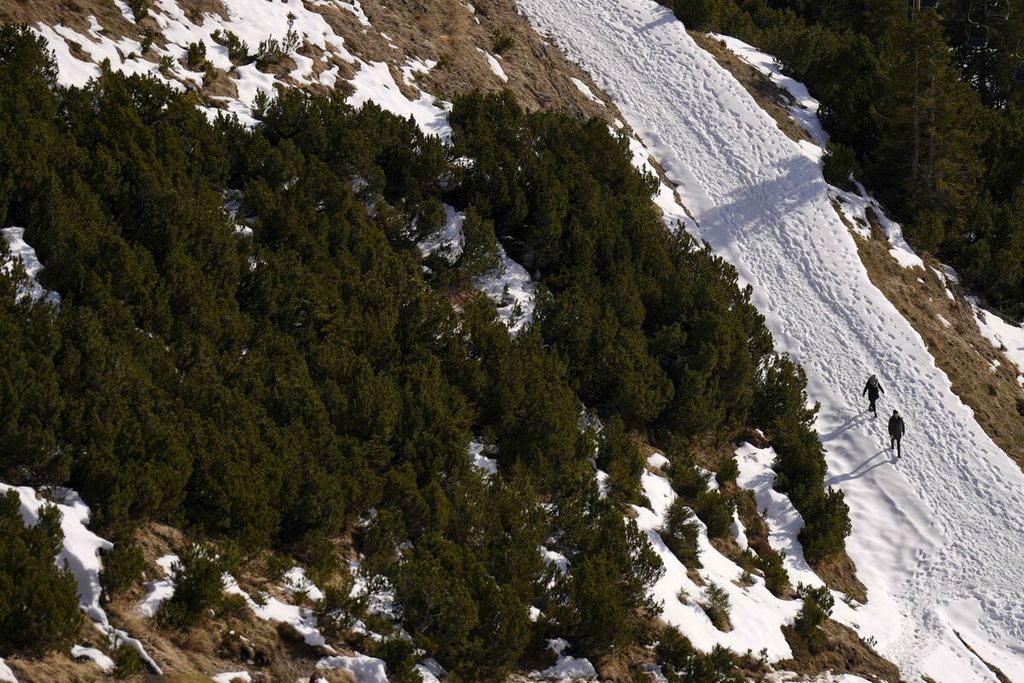 Pelancong di Hafelekar, Austria, bermain ski di jalur yang hanya tersisa sedikit pada 2 Januari 2023. Tempat wisata ski di sekitar Alpen dan Pyrenee kekurangan salju tahun ini. 