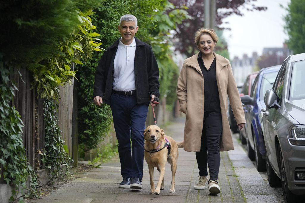Wali Kota London Sadiq Khan dan istrinya, Saadiya Ahmed, berjalan bersama anjing mereka, Luna, saat akan menggunakan suara pada pemilu wali kota London di London, Inggris, 2 Mei 2024. 