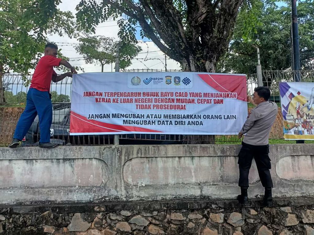 Polisi memasang spanduk imbauan bahaya pemberangkatan ilegal pekerja migran di Batam, Kepulauan Riau, Kamis (27/4/2023).