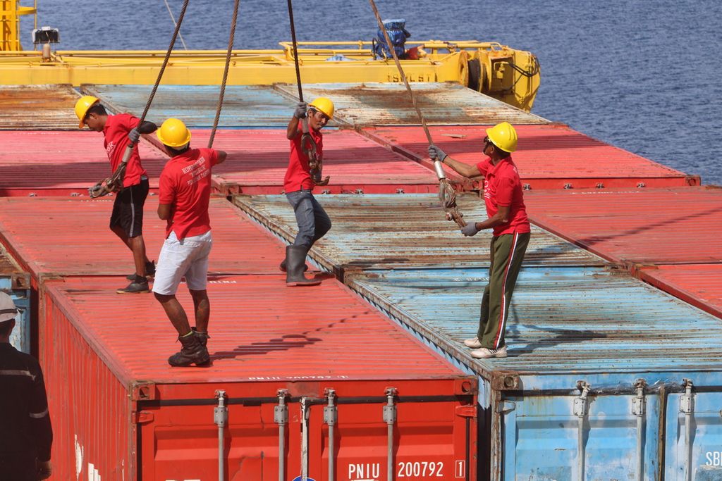 Sejumlah buruh bongkar muat barang mengaitkan kontainer di atas kapal Logistik Nusantara 2 yang merapat di Pelabuhan Tahuna, Kabupaten Kepulauan Sangihe, Sulawesi Utara, Selasa (28/11/2023).