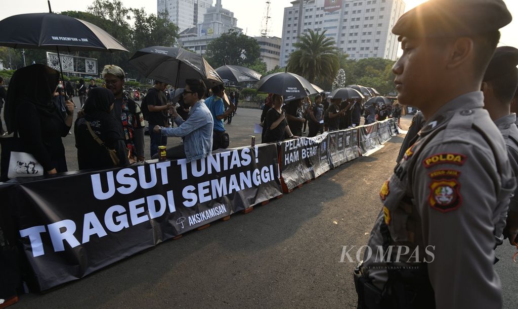 Polisi berjaga di depan para aktivis dan sukarelawan Jaringan Solidaritas Korban untuk Keadilan (JSKK) yang mengikuti aksi diam Kamisan ke-609, di depan Istana Merdeka, Jakarta, Kamis (7/11/2019). 