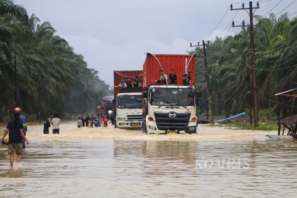 Jalan Medan-Banda Aceh sudah empat hari lumpuh karena banjir yang merendam sejumlah ruas jalan di Kabupaten Aceh Tamiang, Aceh, hingga Sabtu (5/11/2022). Ribuan kendaraan truk, bus, dan mobil pribadi sepanjang 10-15 kilometer bermalam di jalan menunggu banjir surut. Angkutan logistik Medan-Aceh pun putus total selama empat hari ini.