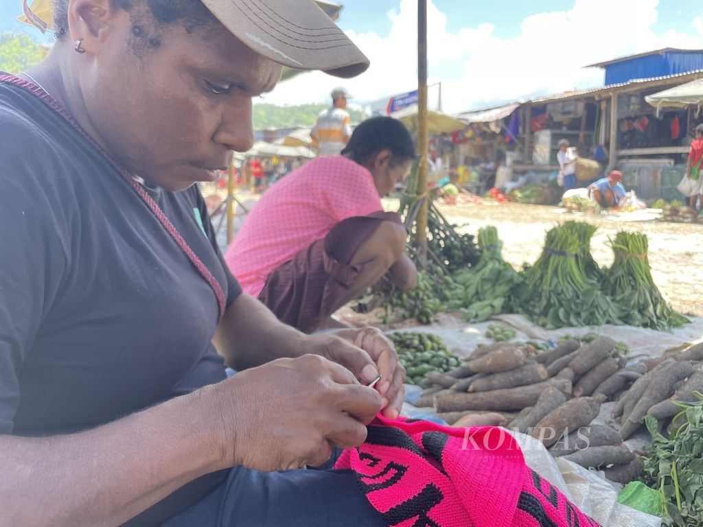 Aktivitas pedagang orang asli Papua atau ”mama Papua” di Pasar Youtefa, Kota Jayapura, Papua, Selasa (17/10/2023). Sambil berjualan, Egana Pagawa menganyam noken untuk dijual kepada pedagang lain.