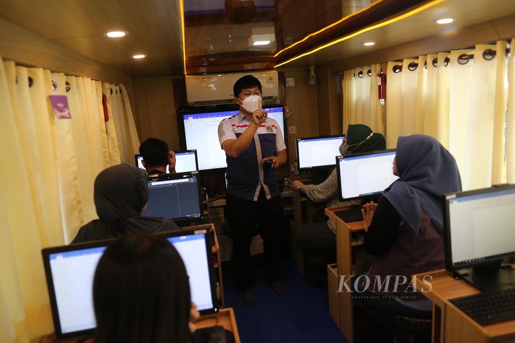 Instruktur Pusat Pelatihan Kerja Daerah Jakarta Timur memberi pelatihan komputer gratis kepada warga Rusun Jatinegara di dalam bus keliling, Mei 2022. 
