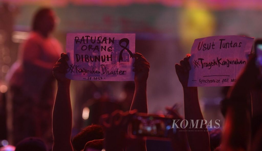 Penonton membentangkan kertas berisi pesan terkait Tragedi Kanjuruhan di salah satu panggung pertunjukan Synchronize Fest 2022 di Jakarta. 